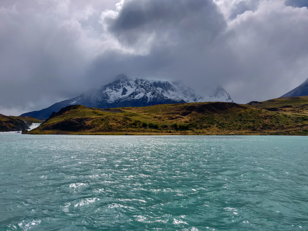 Crazy blue water with cloudy mountains in the background