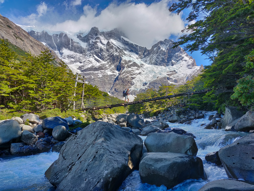 Suspension bridge with mountains behind it