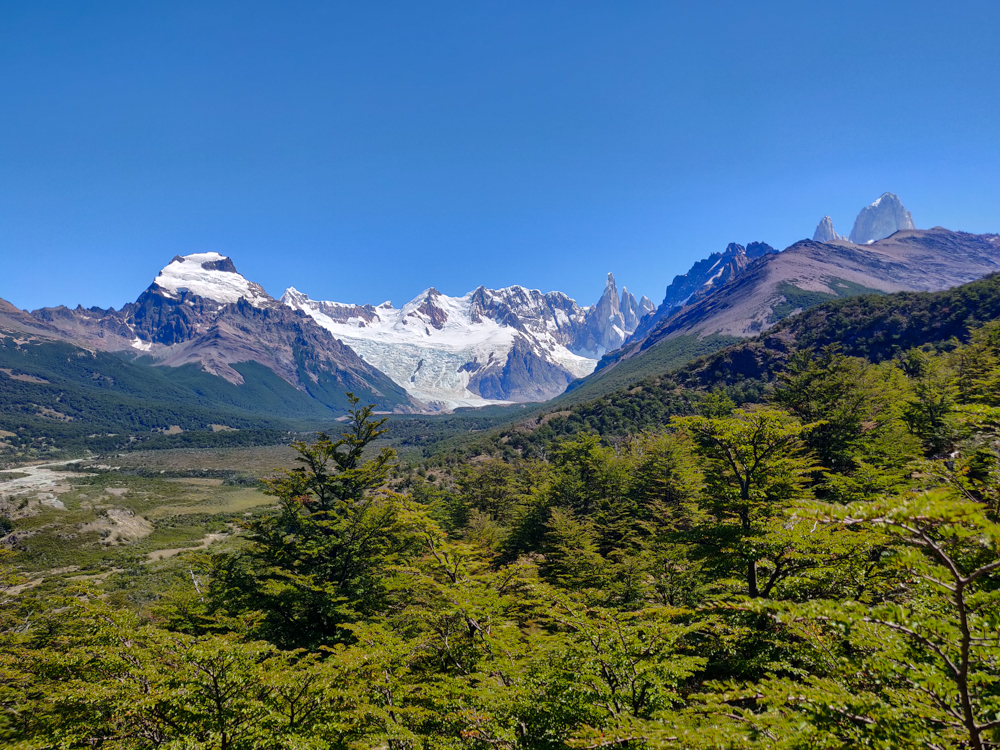 Green landscape with mountains and a glacier in the distance