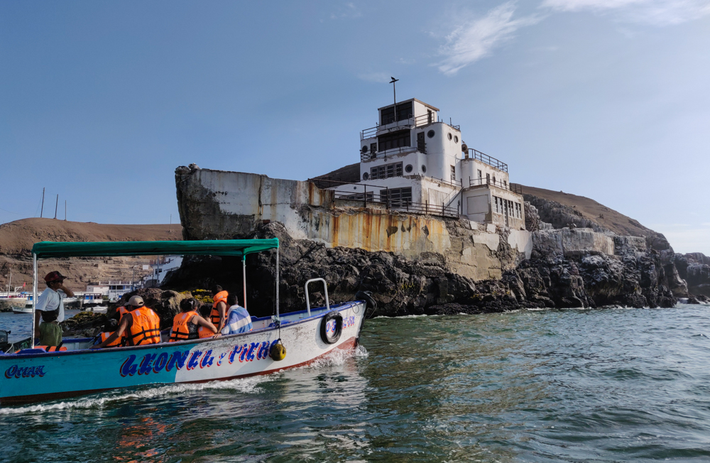 A big, concrete building on the coast in the shape of a boat