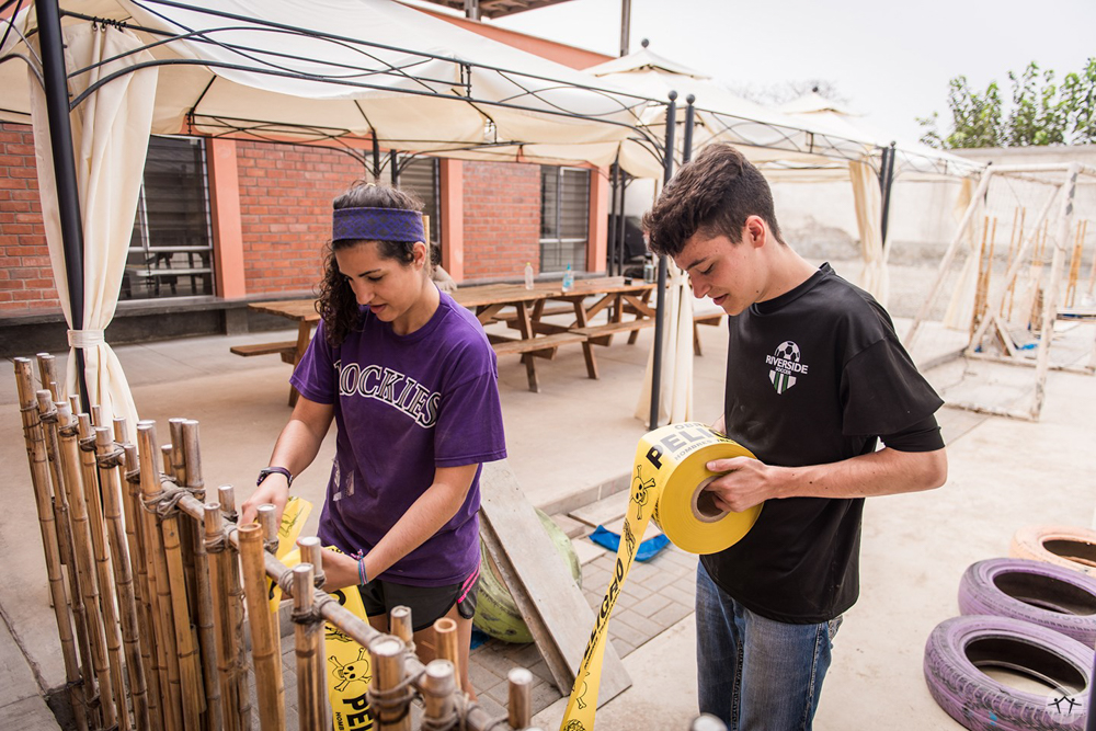 Me and a team member tying caution tape around our fence-in-progress