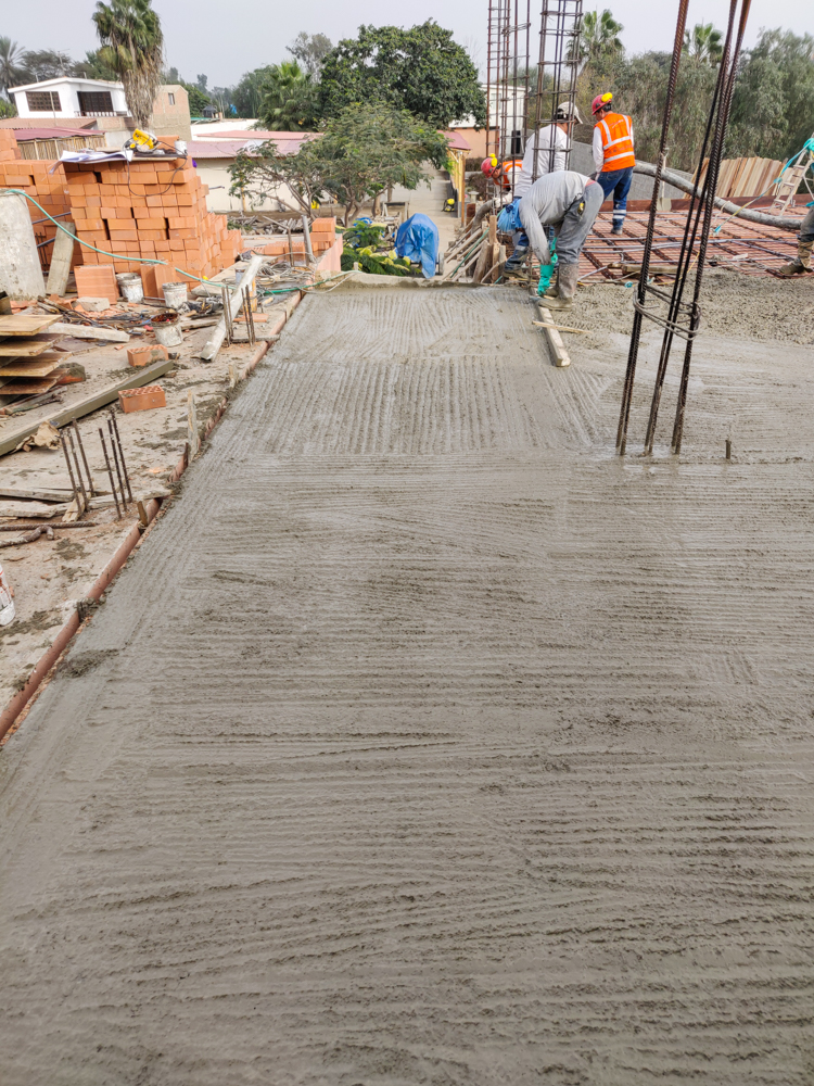 A dude with a board texturizing the top of the concrete